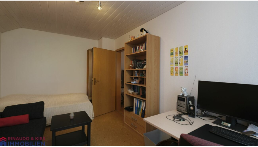 Schlichtes Schlafzimmer mit Schreibtisch und Bücherregal