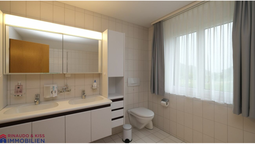 Helles Badezimmer mit Doppelwaschtisch und Fenster