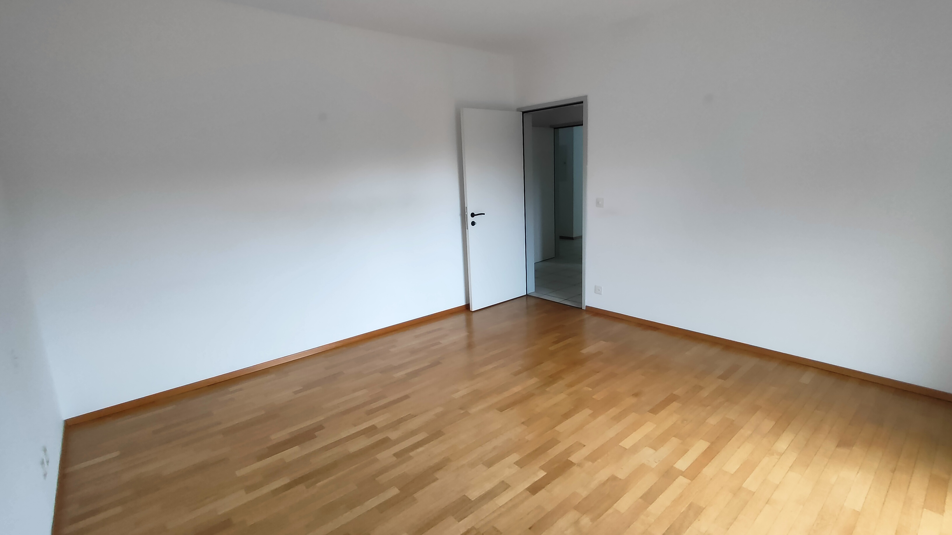 Leerer Raum mit Parkett und offener Tür