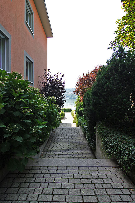 Zugang zwischen Haus und Garten mit Blick auf Wasser