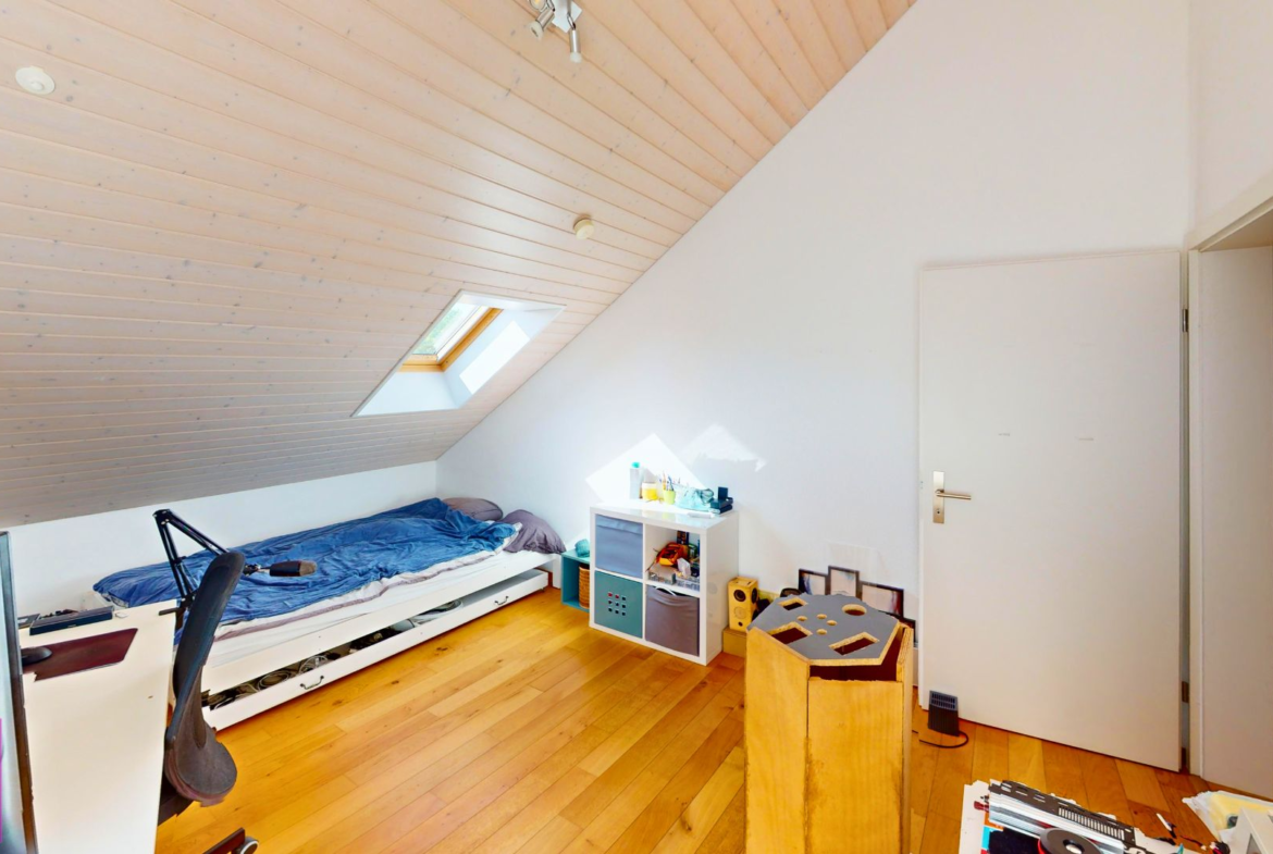 Dachzimmer mit Bett und Dachfenster