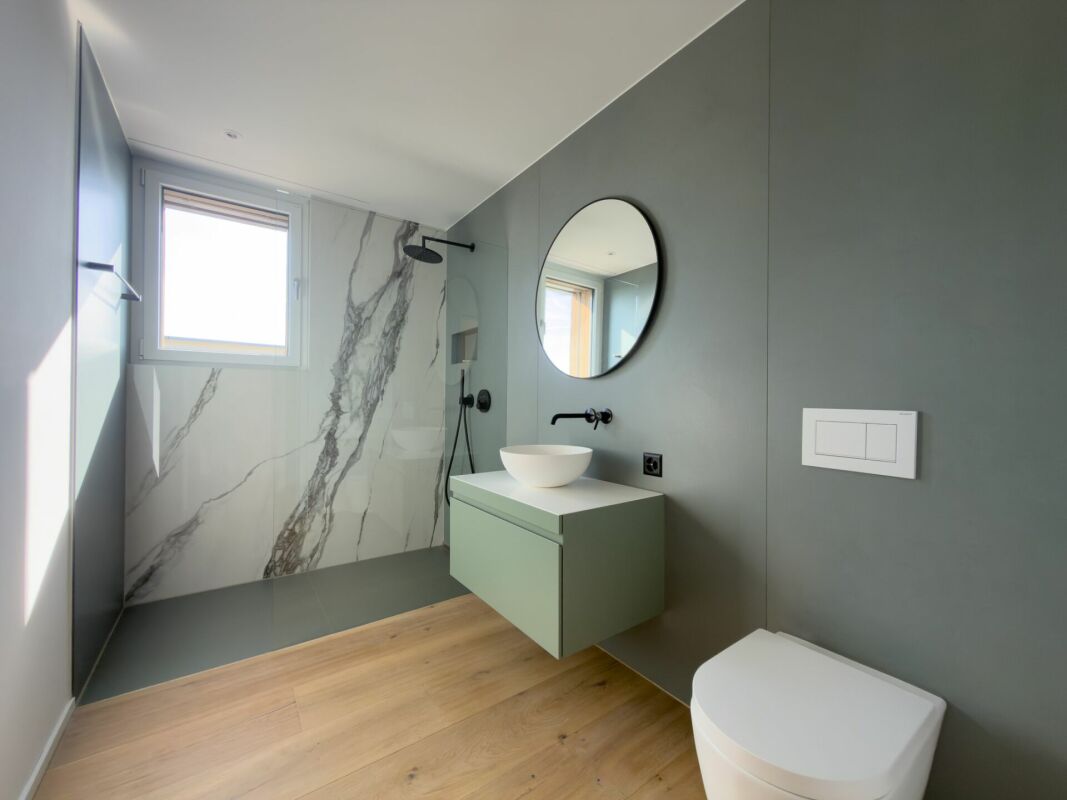 Modernes Badezimmer mit grauen Wänden und Marmorakzenten