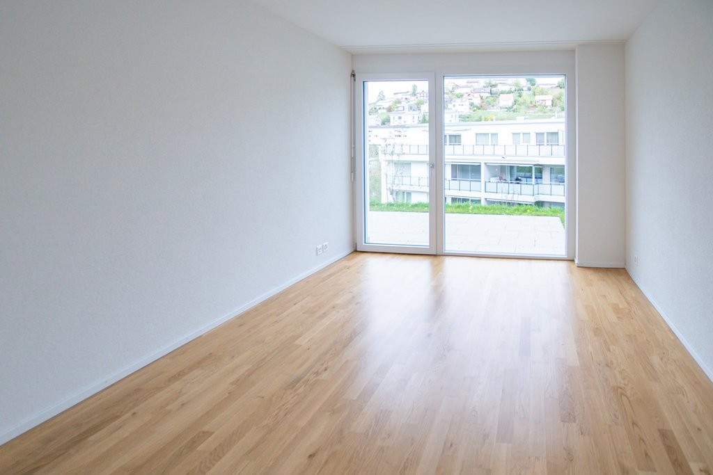 Leerer, heller Wohnraum mit Terrassentür