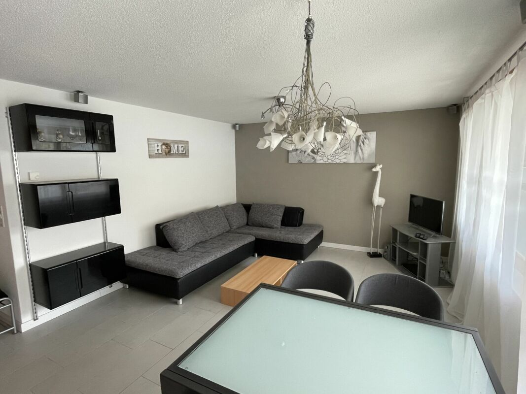 Wohnzimmer mit grauer Eckcouch und TV-Ecke