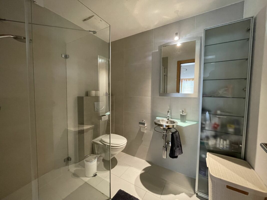 Modernes Badezimmer mit Glasdusche und wandhängendem WC