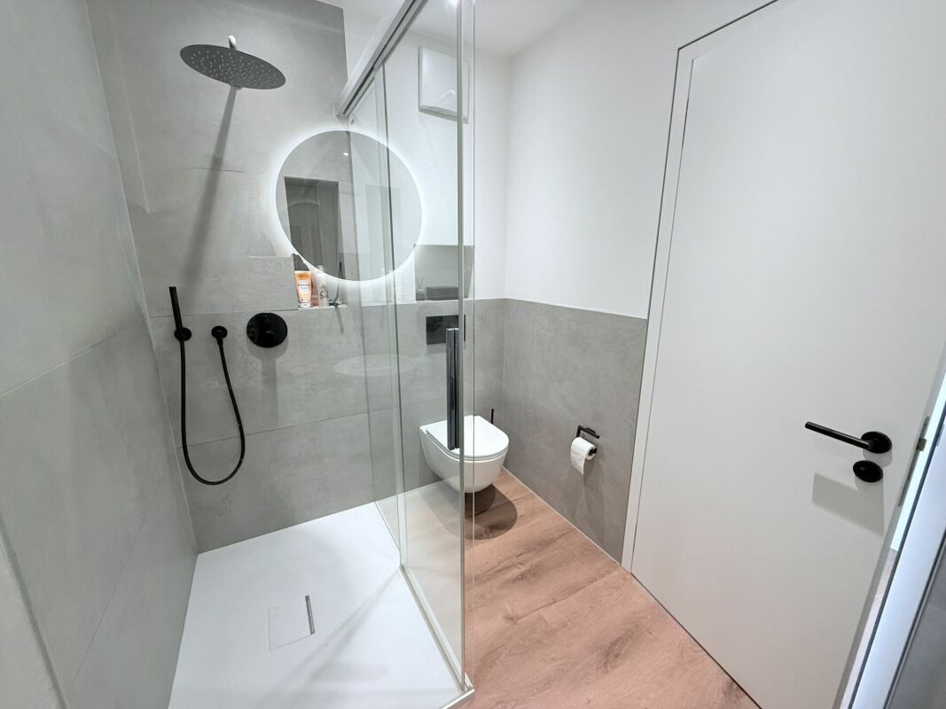 Modernes Badezimmer mit Glasdusche und Wand-WC