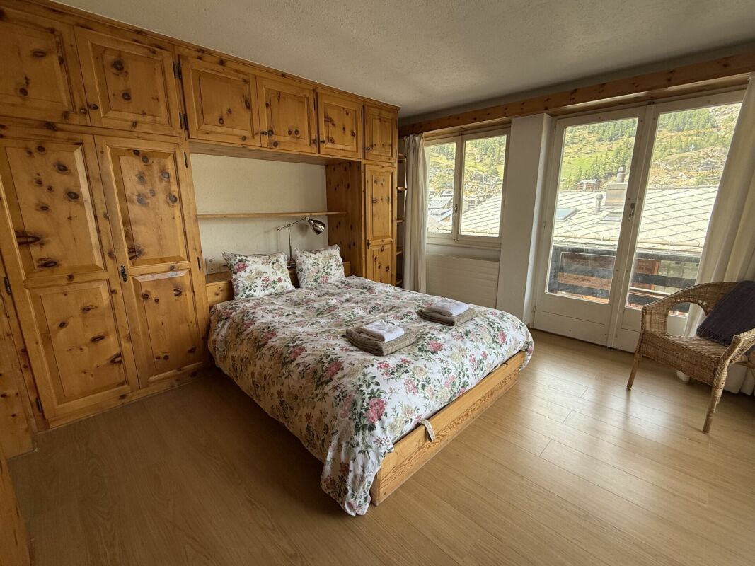 Gemütliches Schlafzimmer mit Holzmöbeln und Bergblick