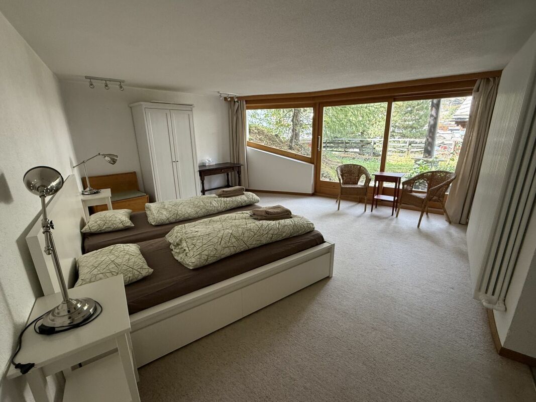 Helles Schlafzimmer mit großem Fensterfrontbereich