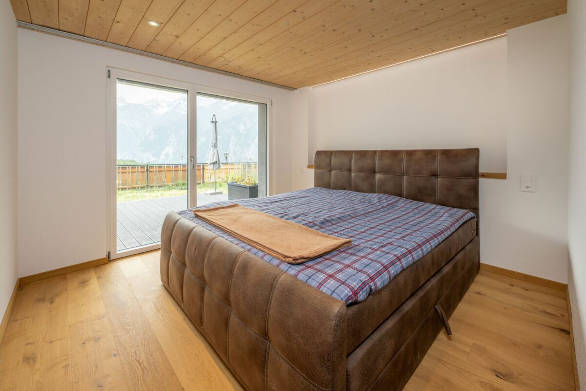 Modernes Schlafzimmer mit Holzelementen und Bergblick