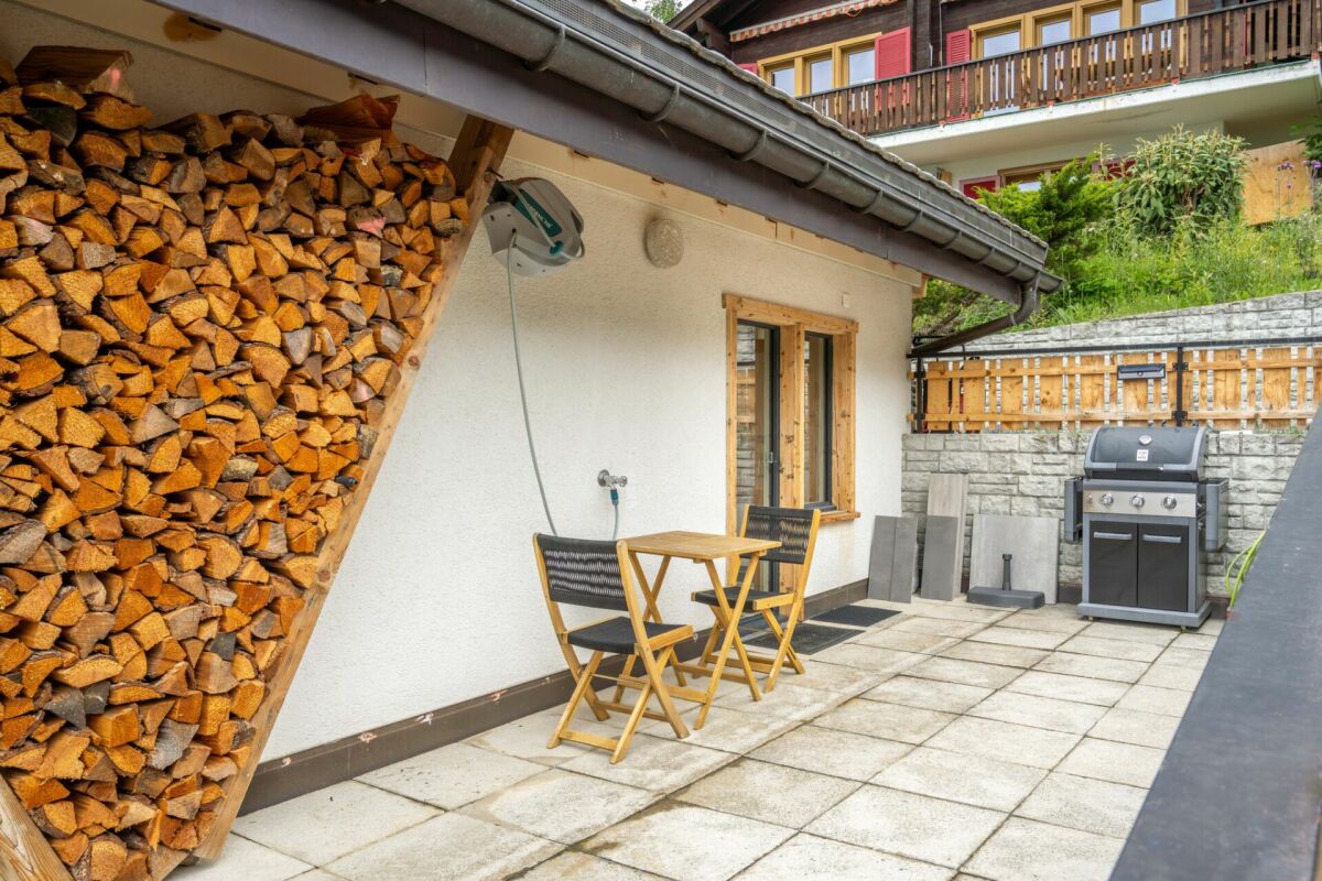 Terrasse mit Holzstapel und Grill