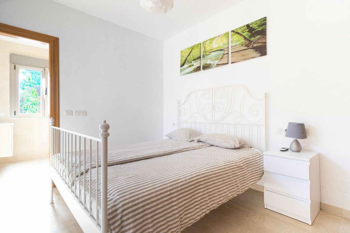 Helles Schlafzimmer mit weißem Metallbett