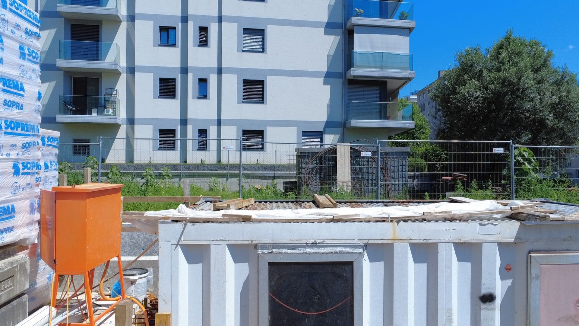 Wohngebäude mit Baustelle im Vordergrund