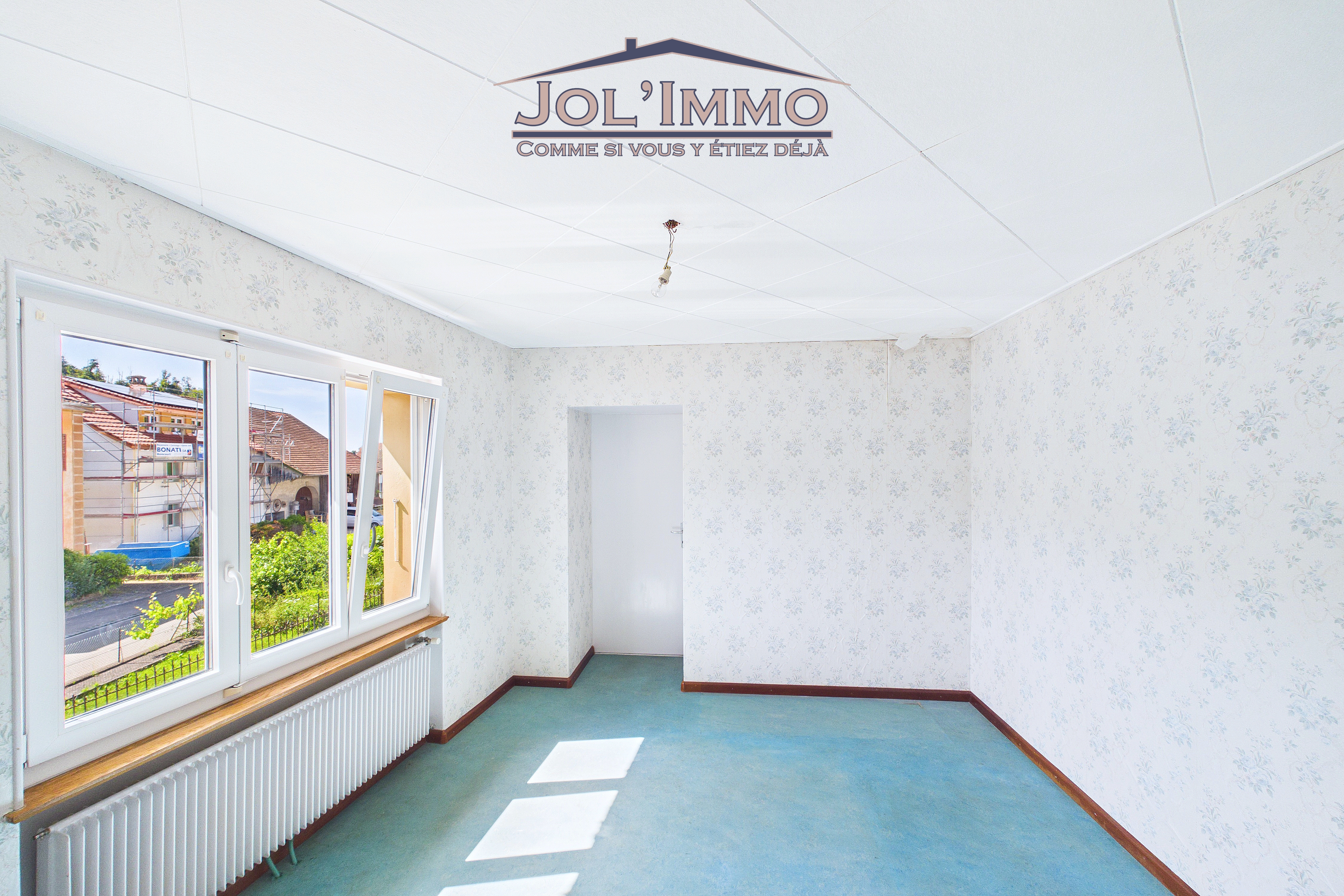 Helles, leeres Zimmer mit Fensterfront und Tapete
