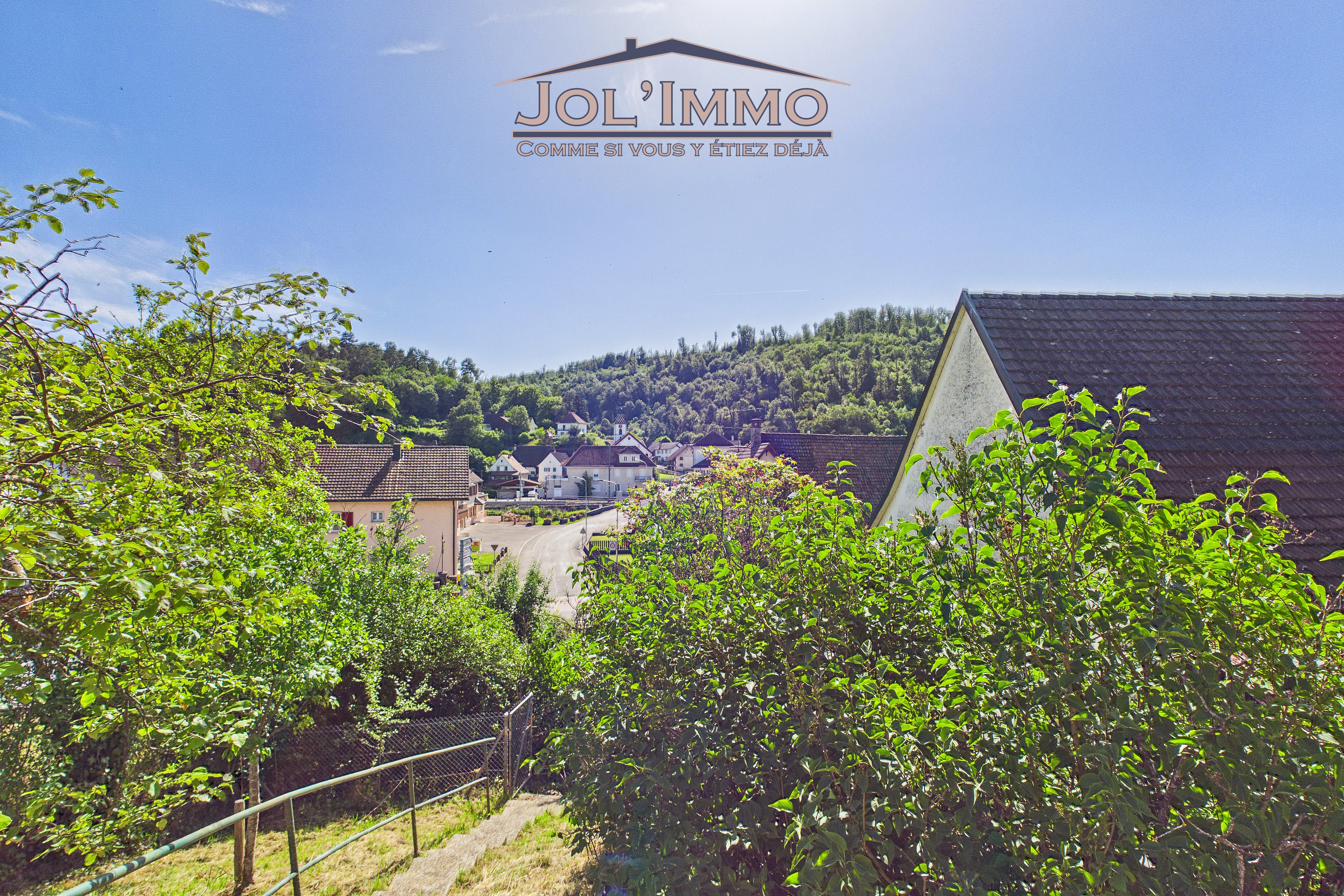 Dorf- und Hügellandschaft mit Gartenblick