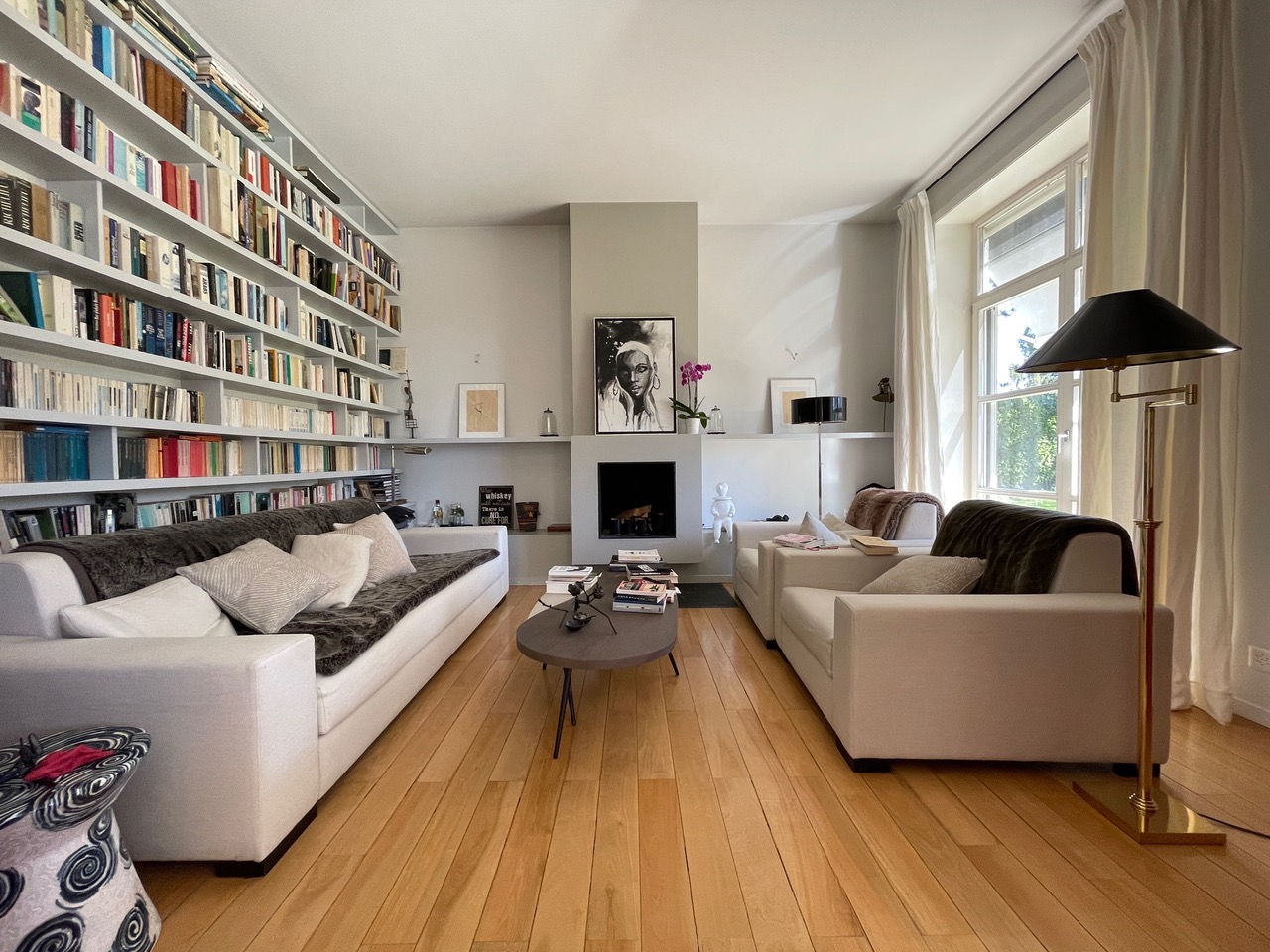 Helles Wohnzimmer mit Bibliothekswand und Kamin