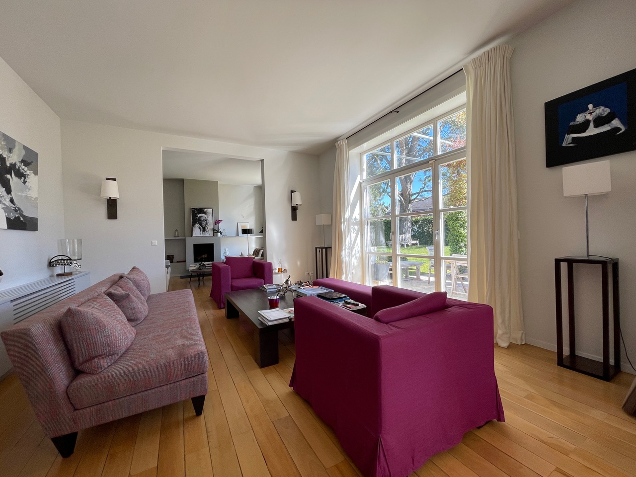 Helles Wohnzimmer mit großem Fenster und Gartenblick