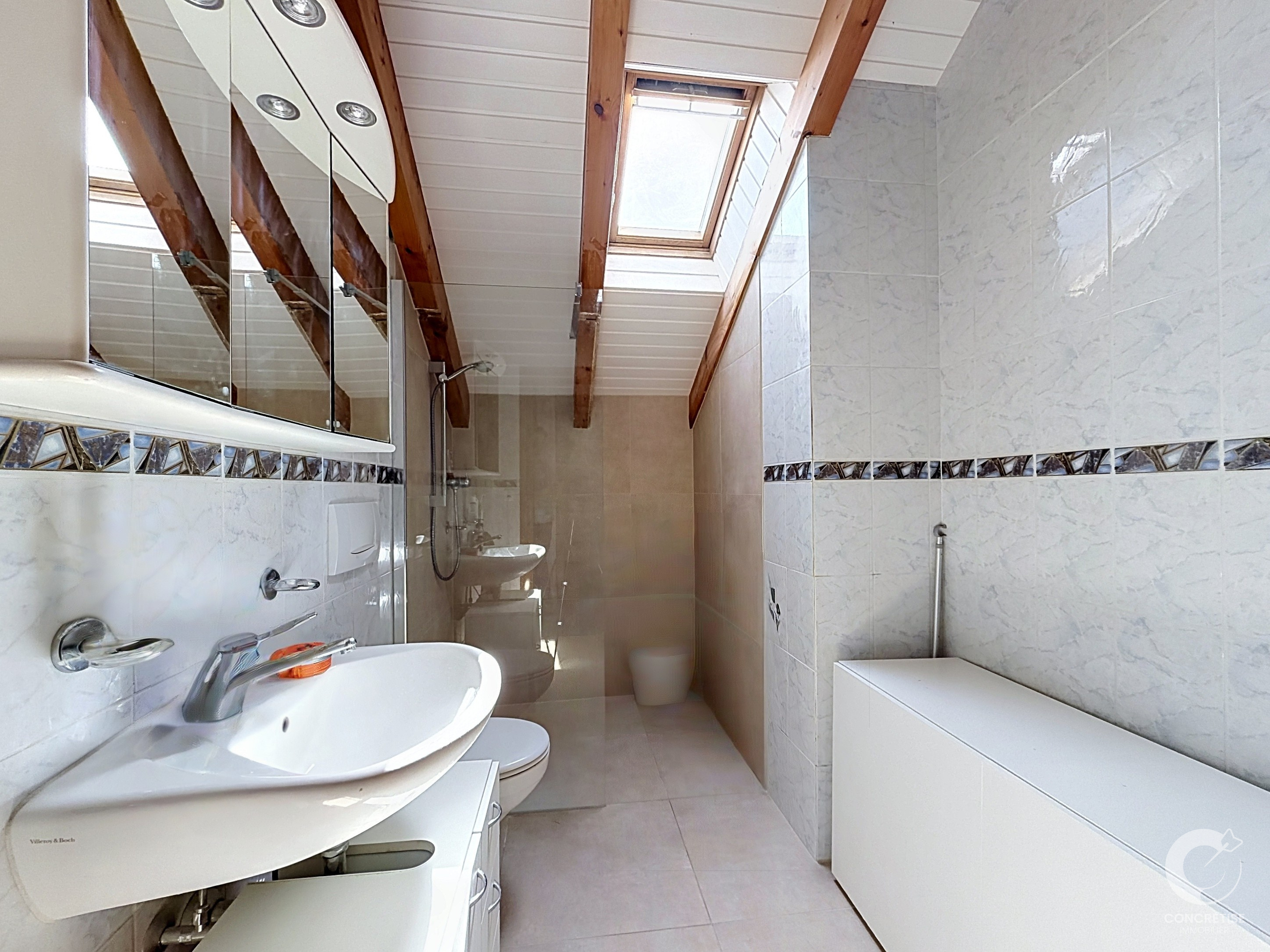 Schmales Dachgeschossbad mit Dachfenster