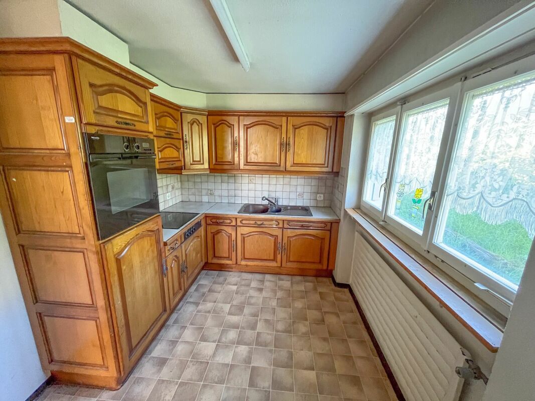 Kleine Einbauküche mit Holzfronten und Fensterwand