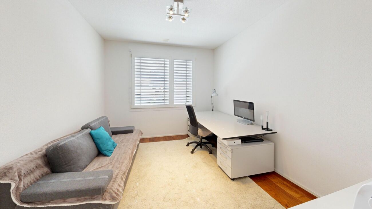 Helles Arbeitszimmer mit Sofa und Schreibtisch