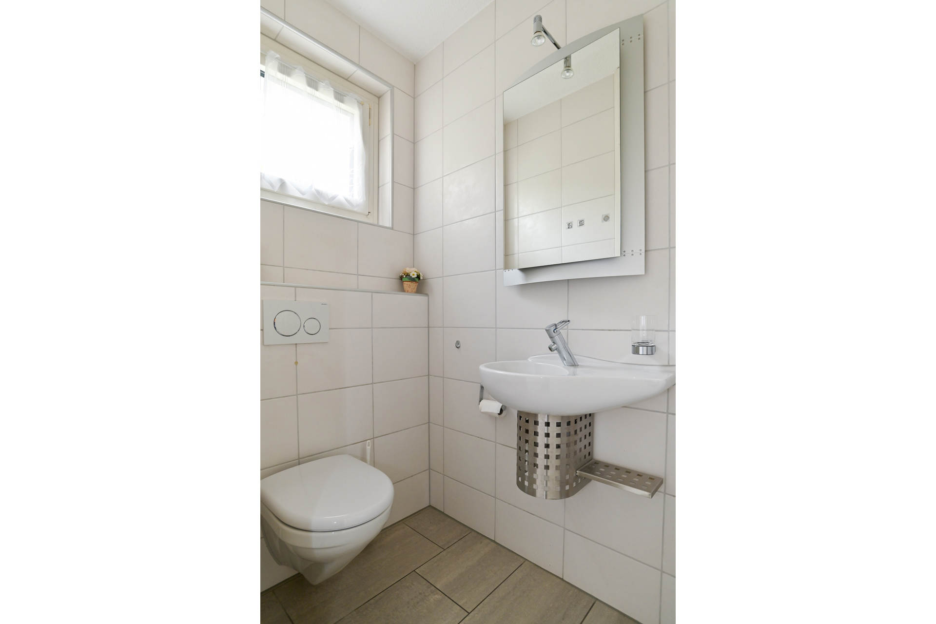 Kleines Gäste-WC mit Wandfliesen, Waschtisch und WC