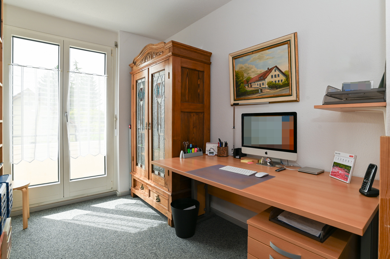 Arbeitszimmer mit Schreibtisch und Vitrine