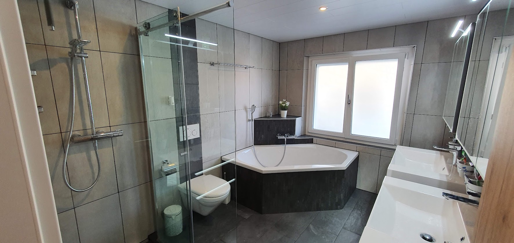 Modernes Badezimmer mit Eckbadewanne und Doppelwaschtisch
