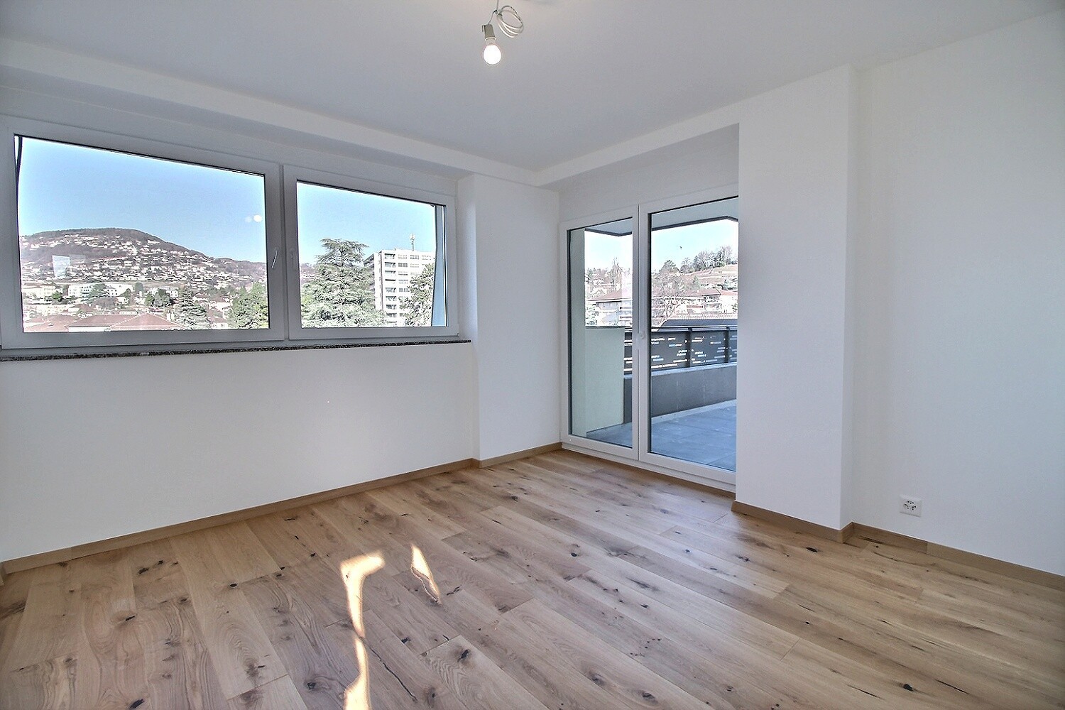 Heller, leerer Wohnraum mit Balkon und Ausblick