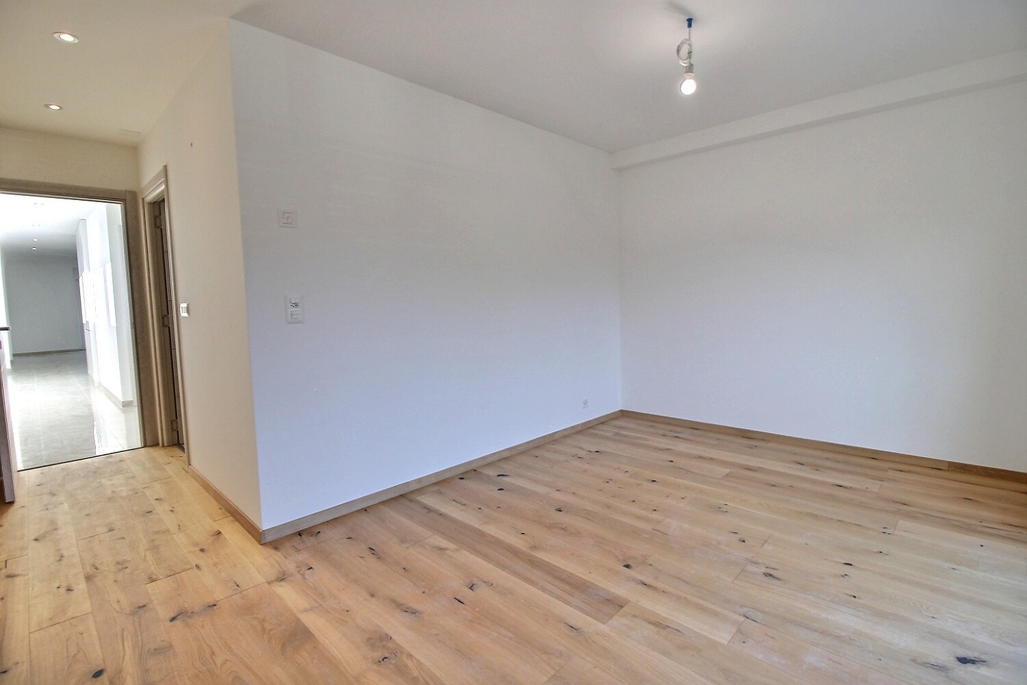 Leeres, helles Zimmer mit Holzfußboden