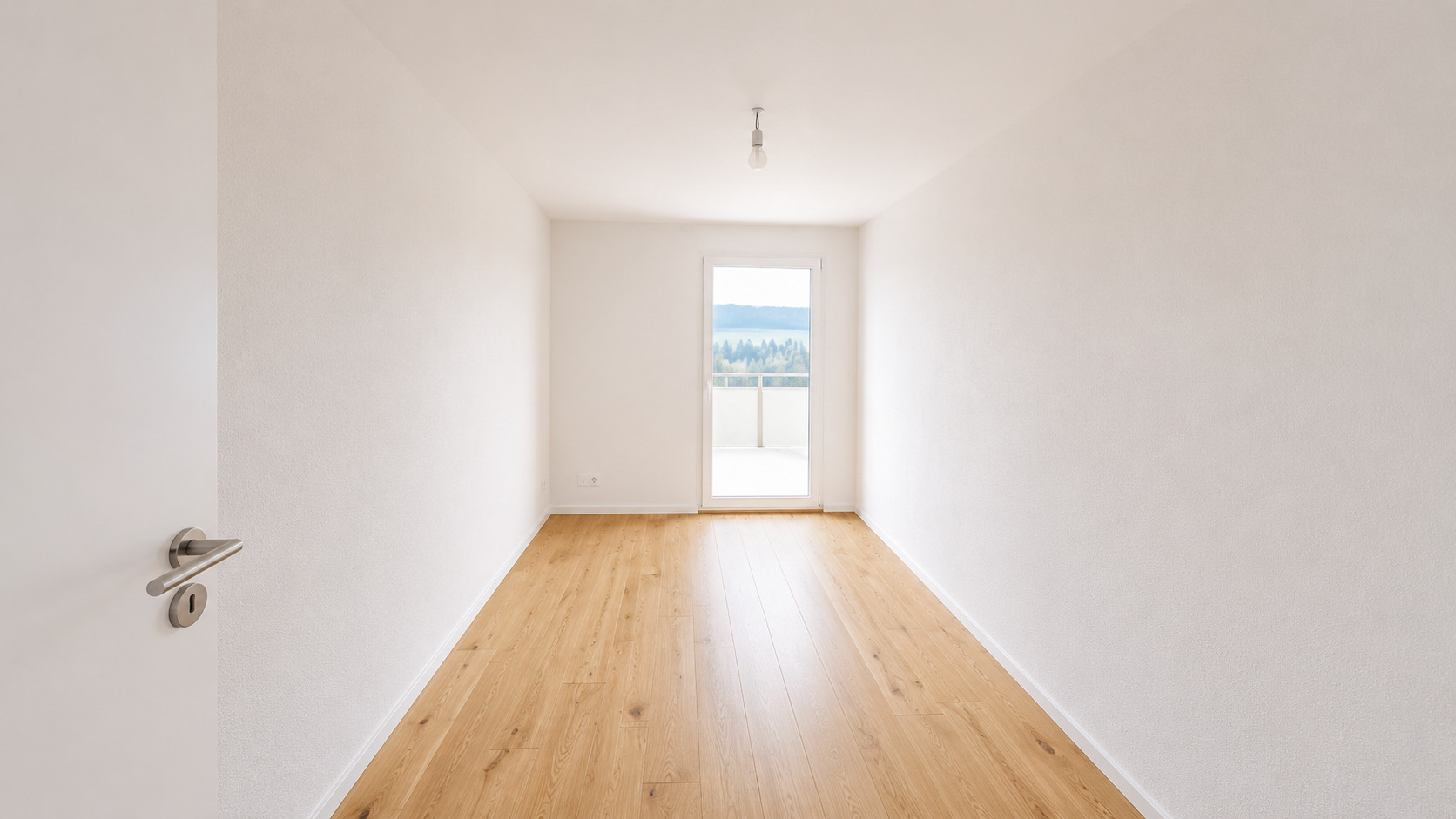 Heller leerer Raum mit Holzboden und Balkonblick