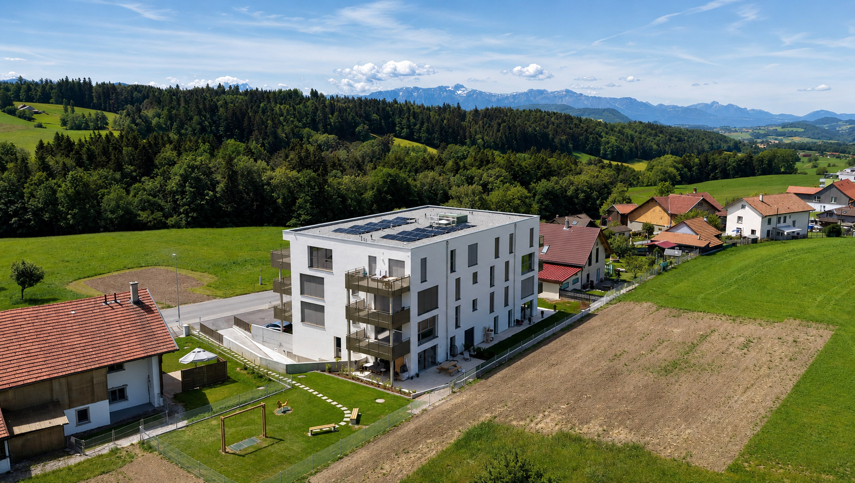 Luftaufnahme eines modernen Wohngebäudes in grüner Hügellandschaft