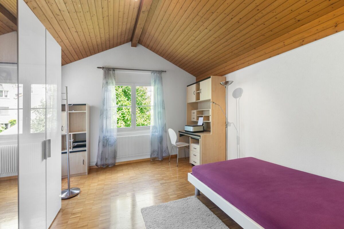 Helles Dachzimmer mit Einzelbett und Arbeitsbereich
