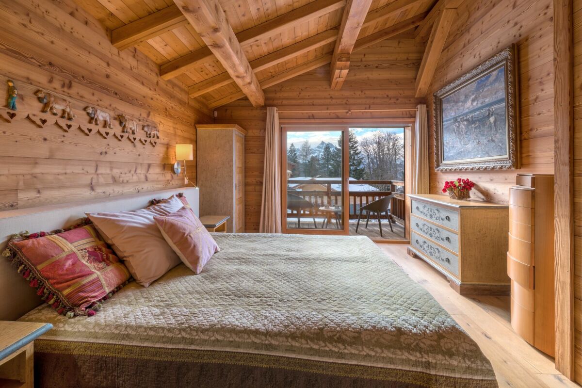 Gemütliches Holz-Schlafzimmer mit Balkonblick