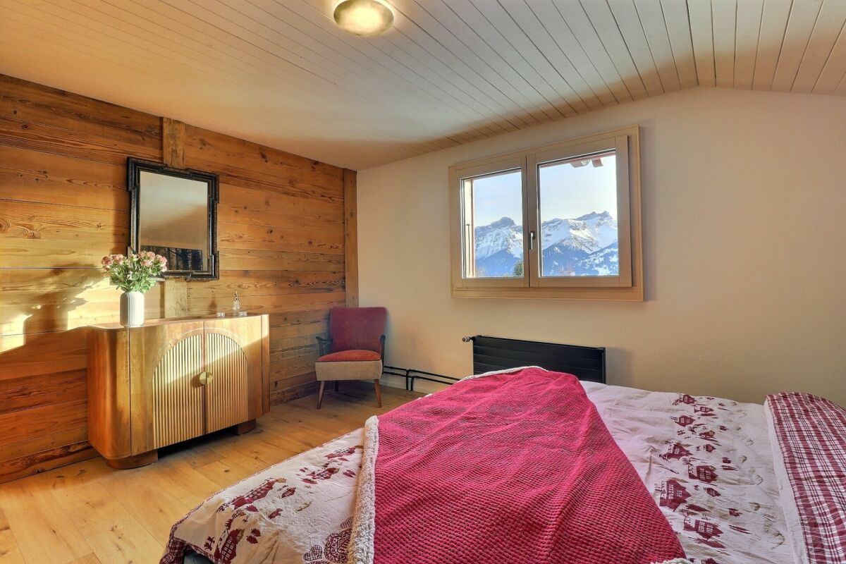 Gemütliches Schlafzimmer im alpinen Stil mit Bergblick