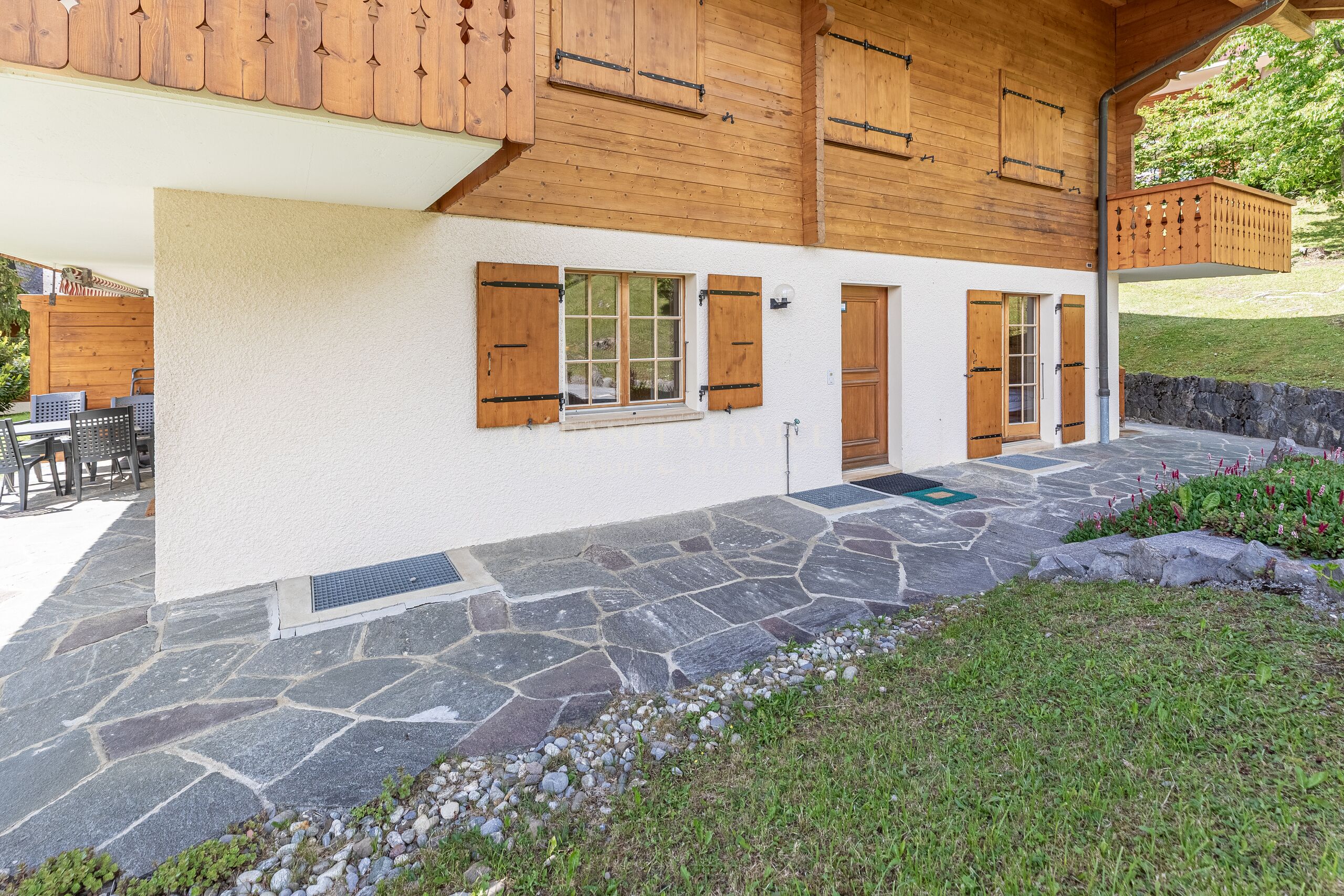 Alpenchalet mit Holzbalkonen und Natursteinterrasse