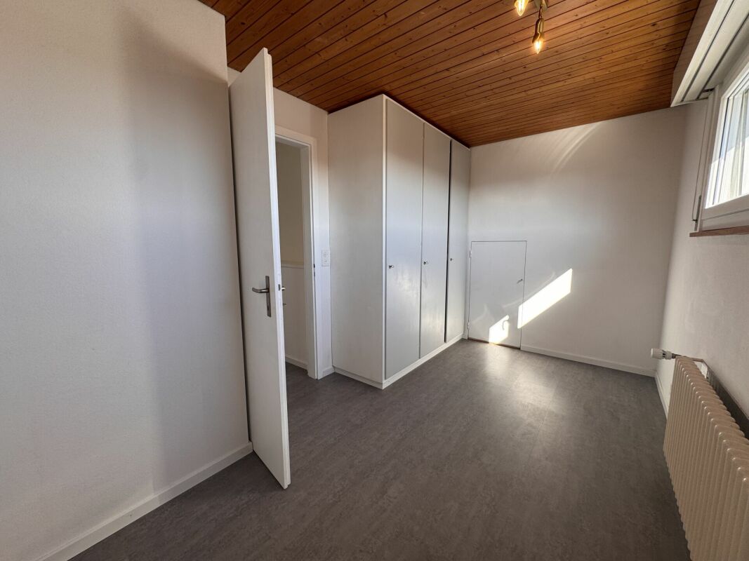 Heller Raum mit Einbauschränken und Holzdecke