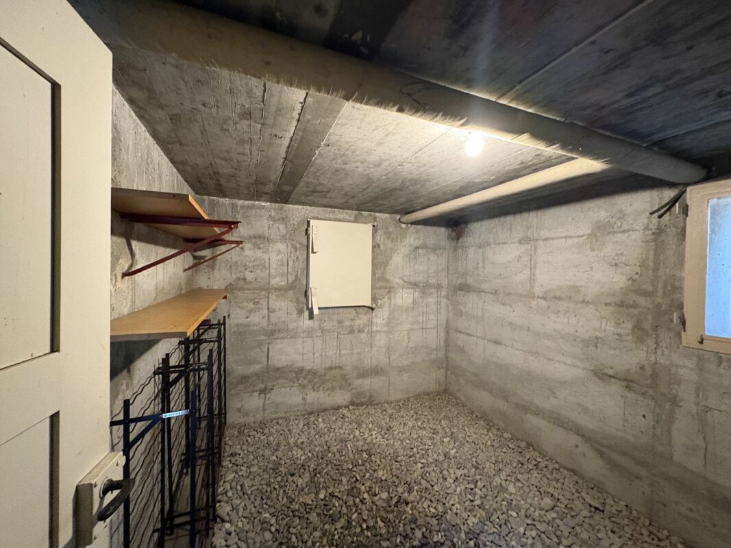 Kellerraum mit Betonwänden und Kiesboden