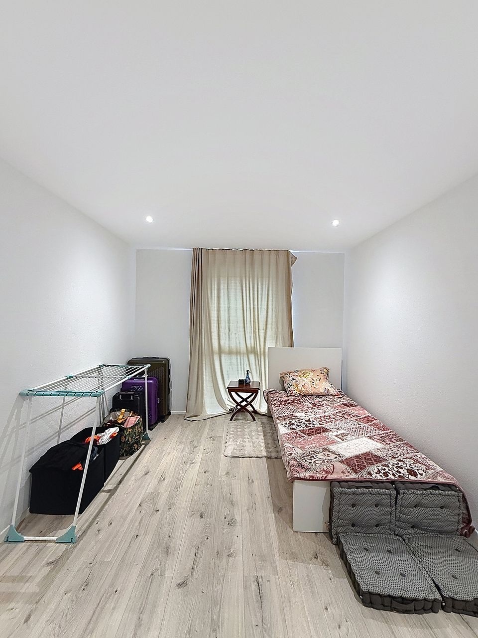 Schmales Schlafzimmer mit einfacher Möblierung