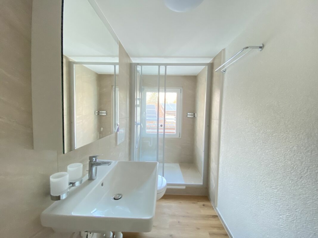 Helles Badezimmer mit Dusche und Waschtisch