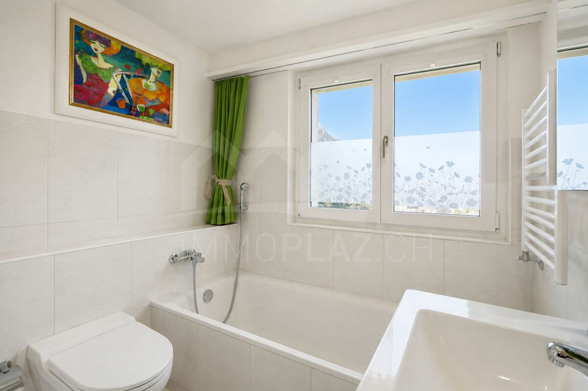 Helles Badezimmer mit Badewanne und Fenster