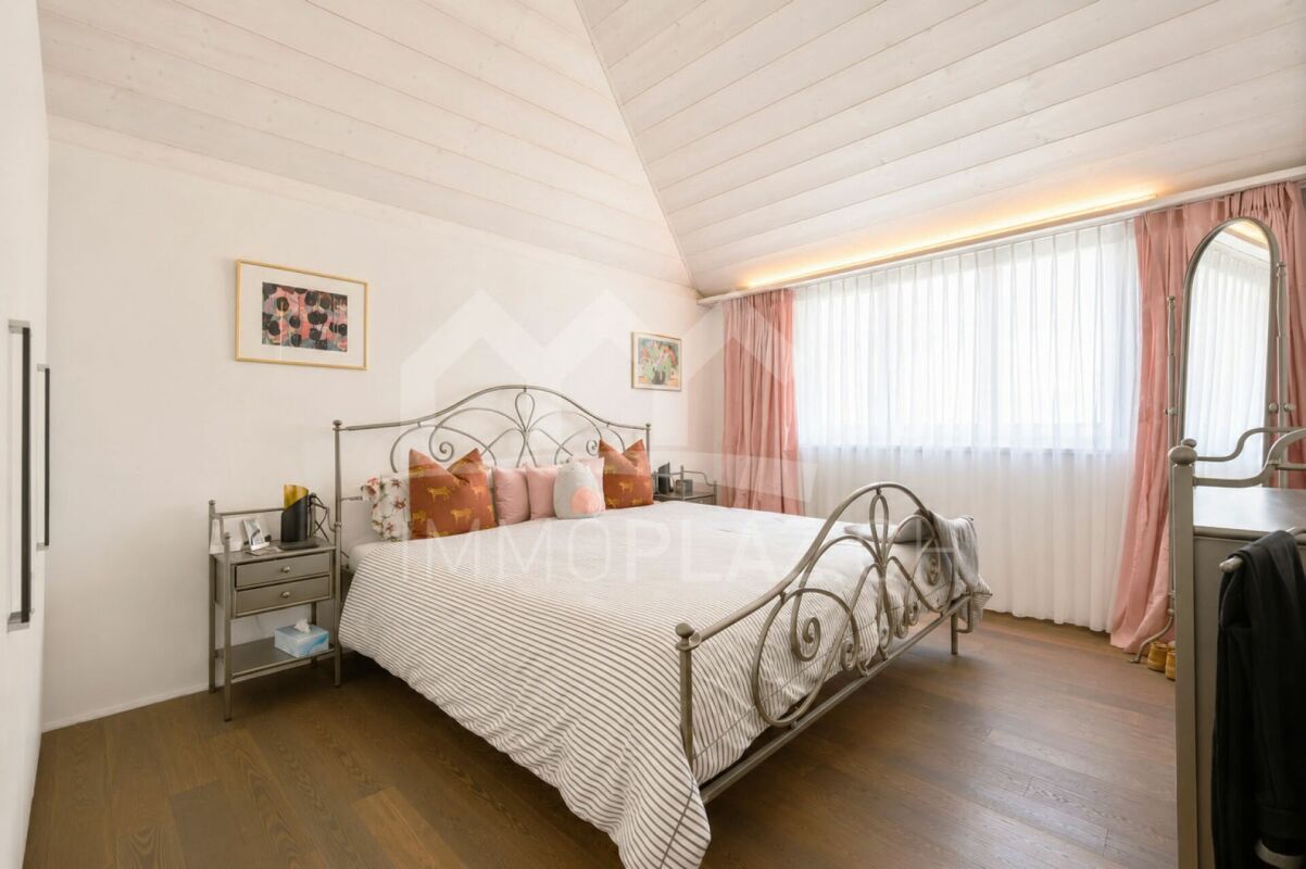 Helles Schlafzimmer mit Metallbett und Dachschräge