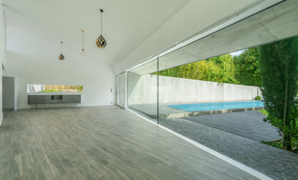 Großer offener Wohnraum mit Glasfront zum Pool