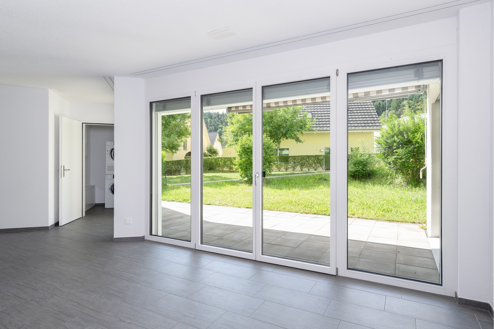 Heller Wohnraum mit großer Fensterfront zum Garten