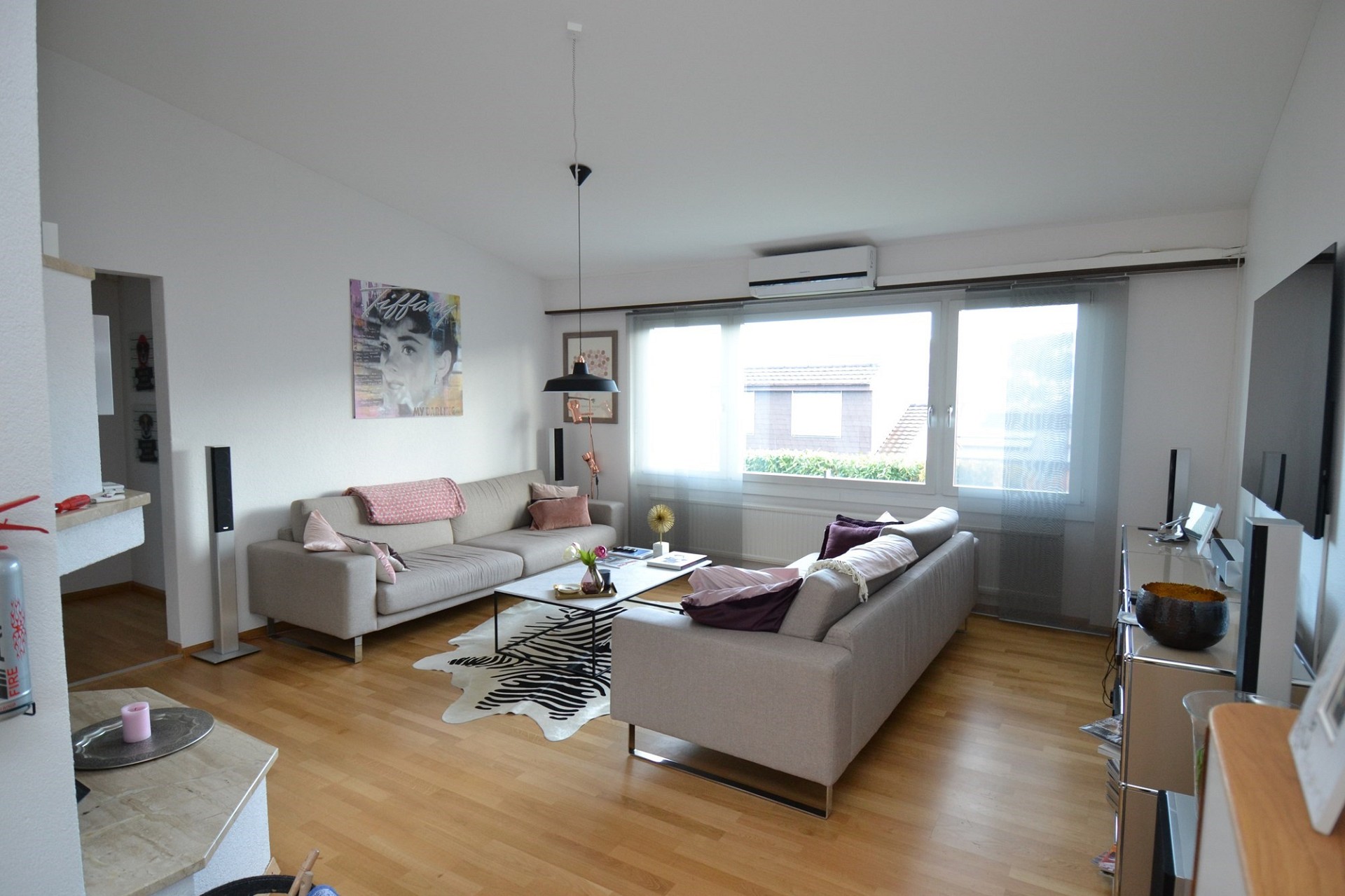 Helles Wohnzimmer mit zwei Sofas und großem Fenster
