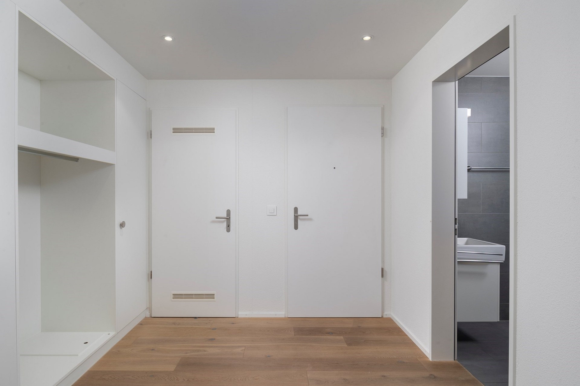 Heller Eingangsbereich mit Garderobenschrank und Badzugang