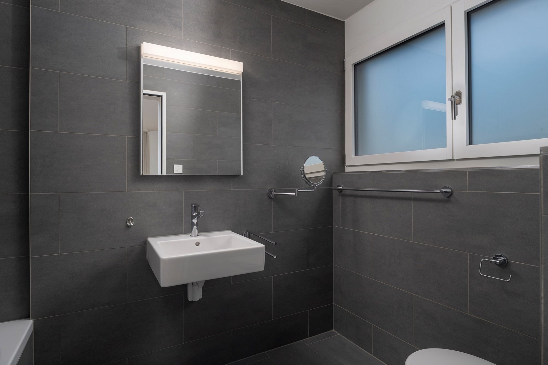 Modernes Badezimmer mit dunklen Fliesen