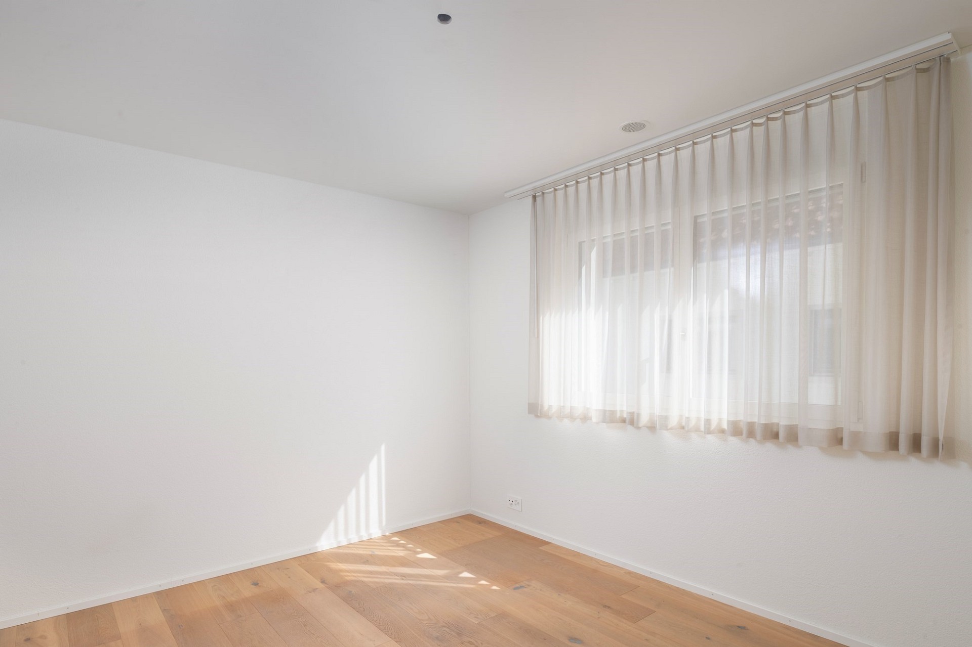 Heller leerer Innenraum mit Fenster und Vorhang