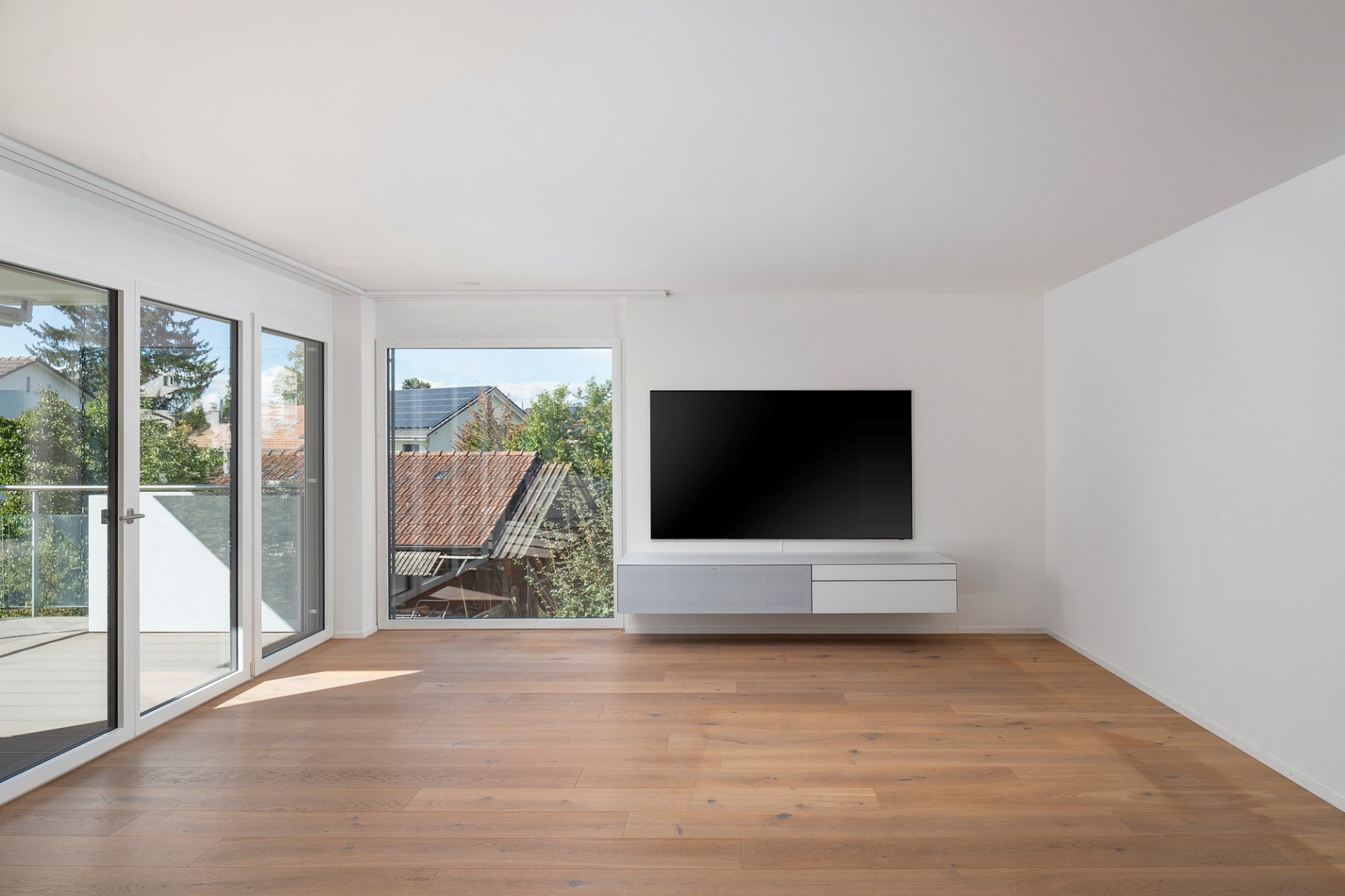 Heller Wohnraum mit Balkon und TV-Wand