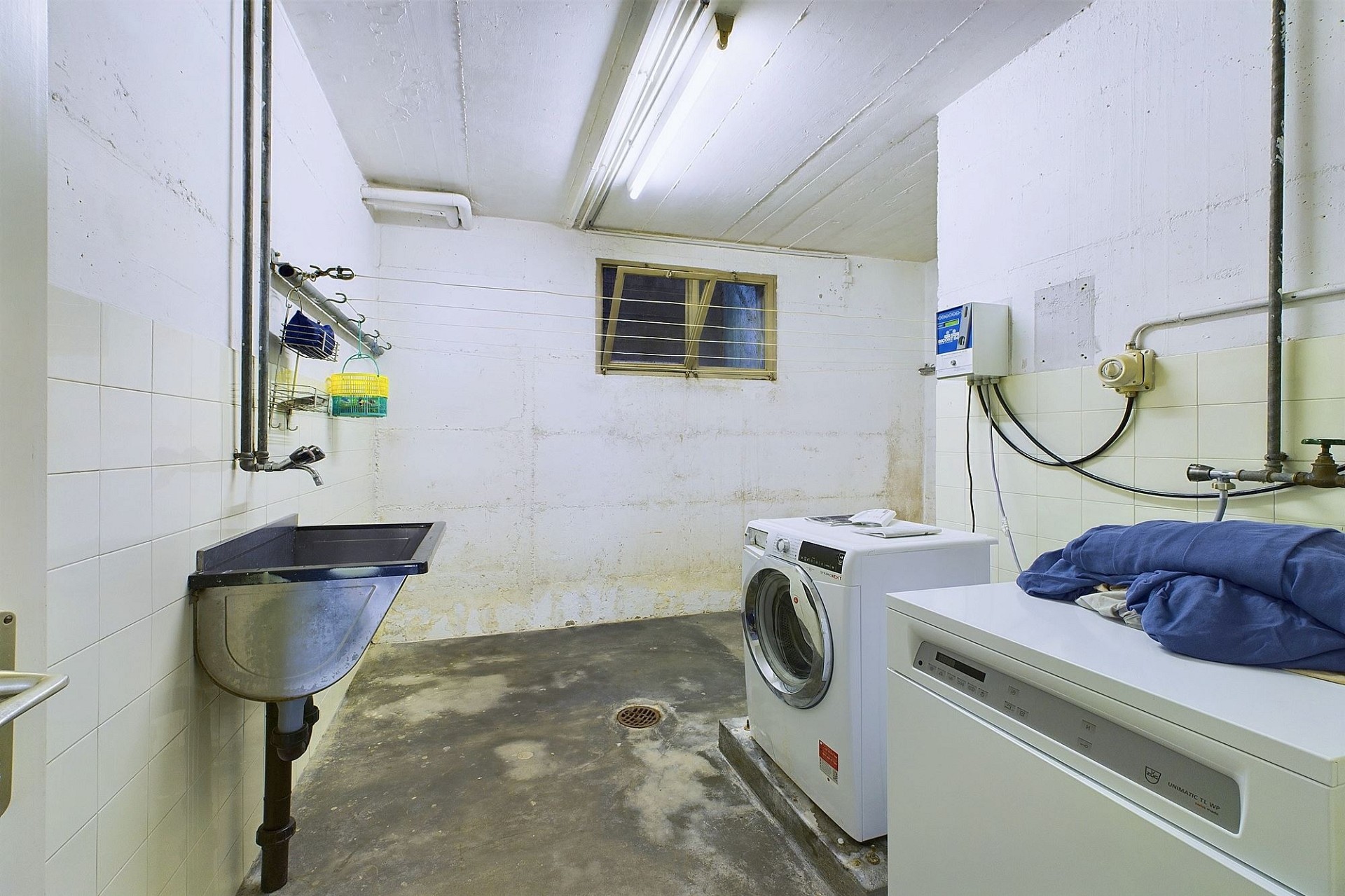 Hauswirtschaftsraum mit Waschmaschine und Spülbecken
