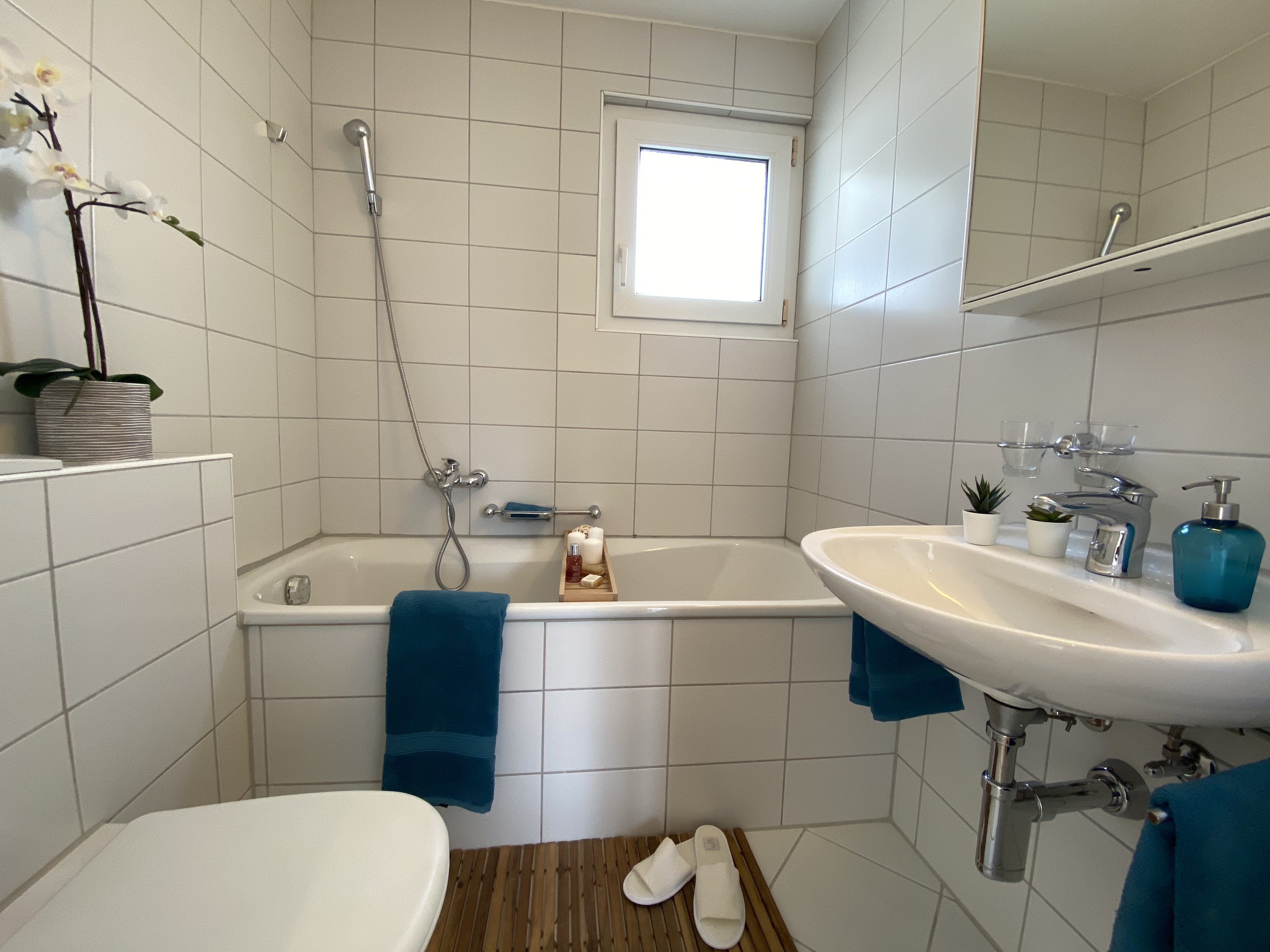 Helles Badezimmer mit Badewanne und Waschtisch