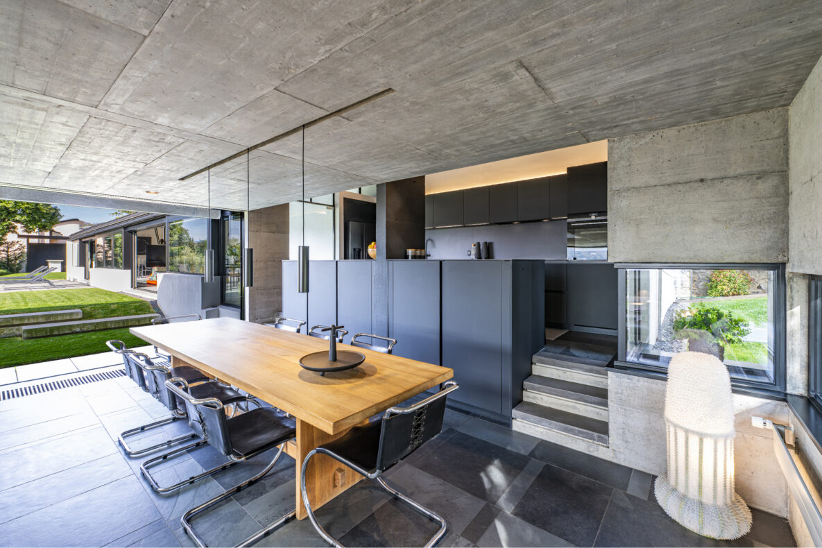 Offene Designküche mit Essbereich und Blick in den Garten